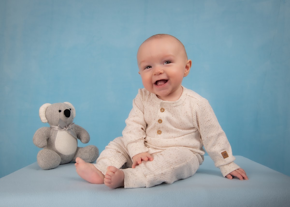 Baby milestone portrait on a blue backdrop